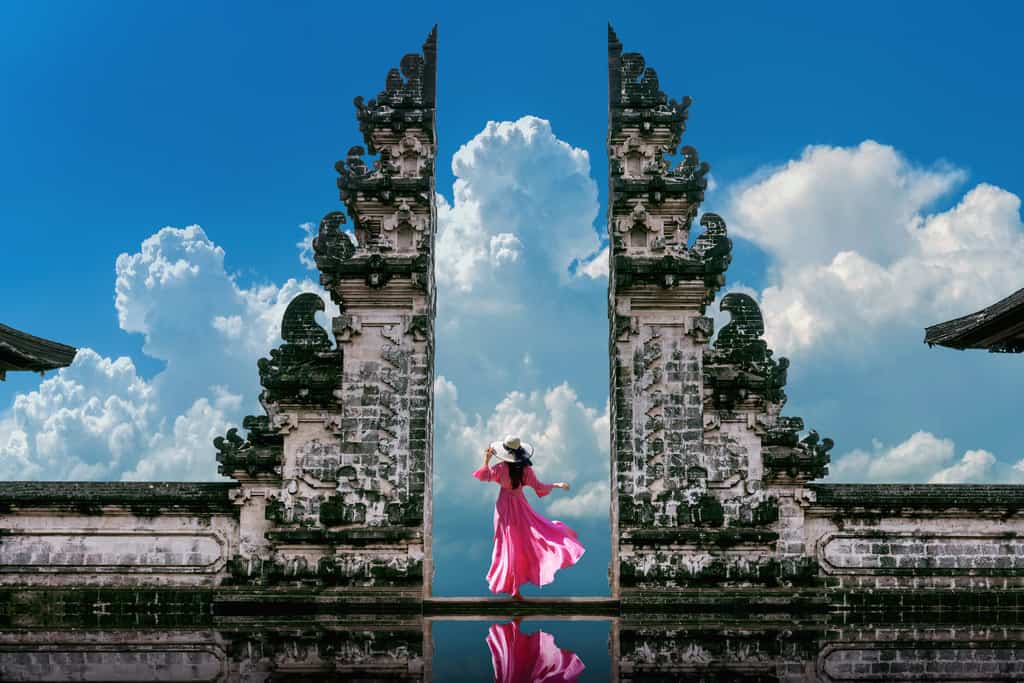 girl with pink dress looking at mount agung from lempuyang gate of heaven
