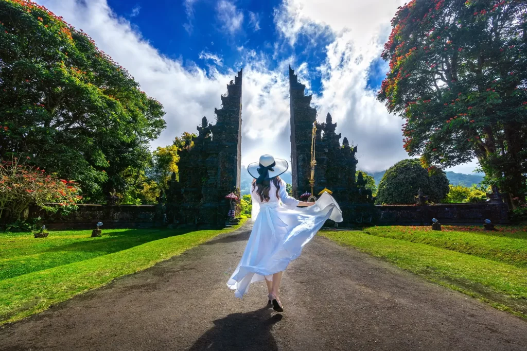 young lady in white dress standing at the front of bali handara gate