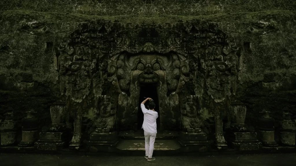 a guy standing and taking photo of goa gajah ubud